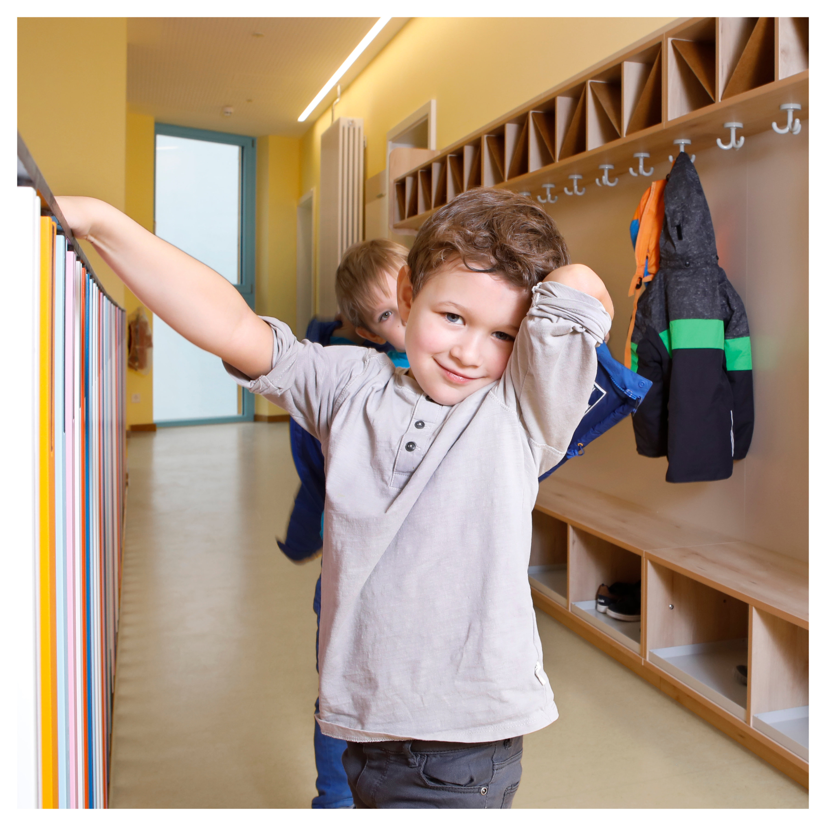Kleiner Junge vor Kindergarderobe